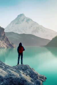 Illustration of a person standing on a rocky outcropping looking at a scenic view